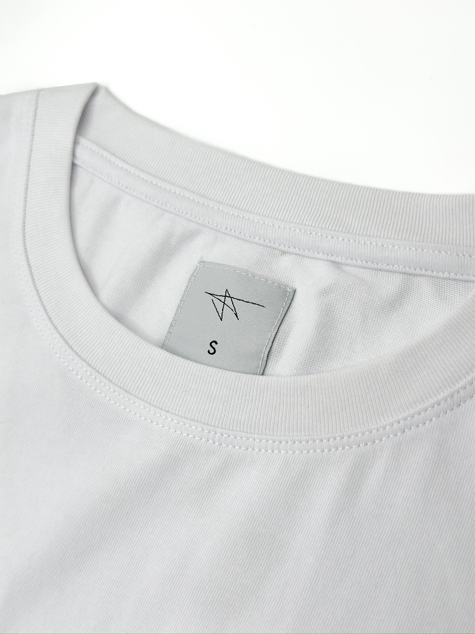 Close-up of a white t-shirt with a label on a white background