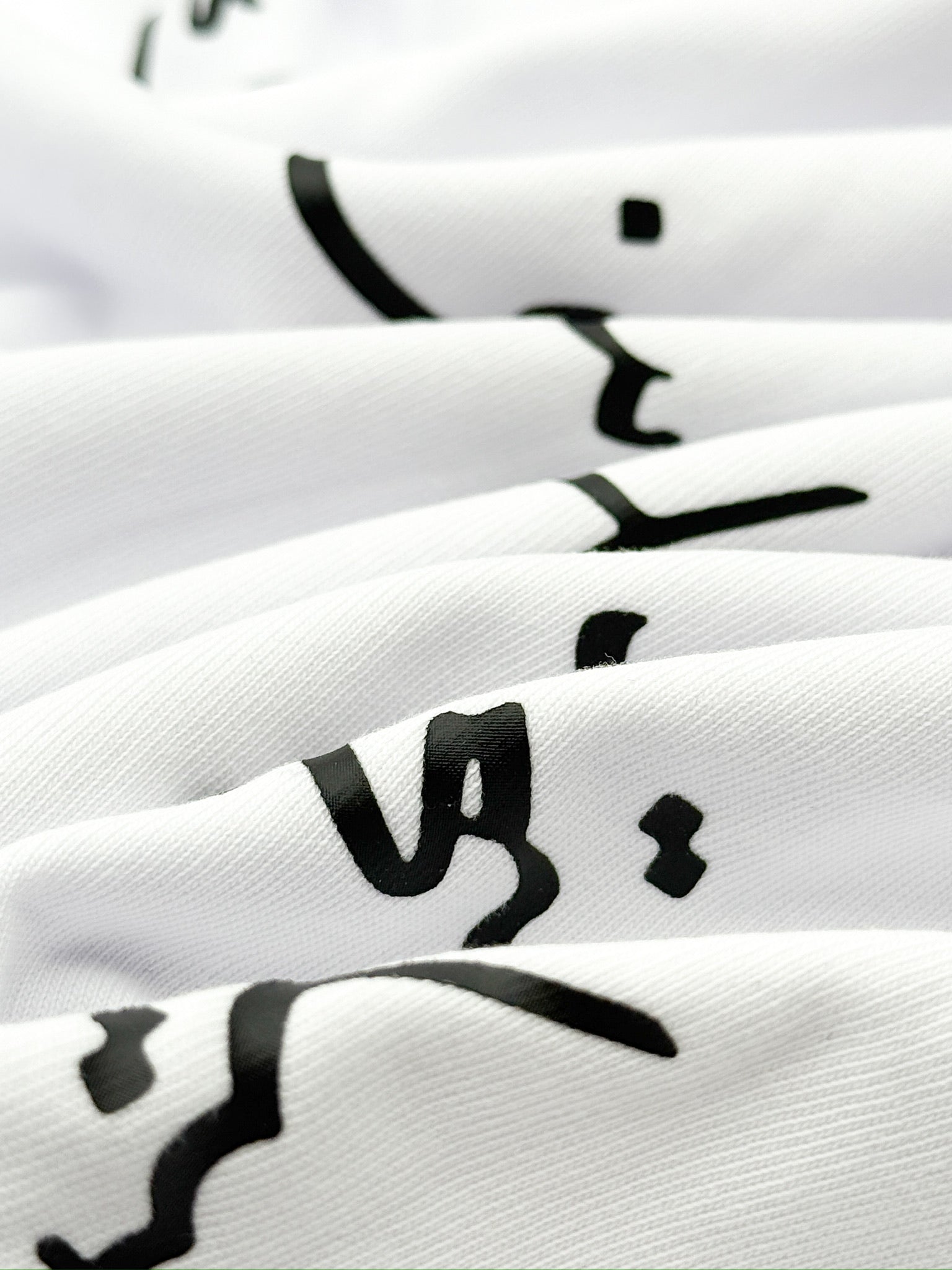 White socks with black geometric patterns stacked on a white background