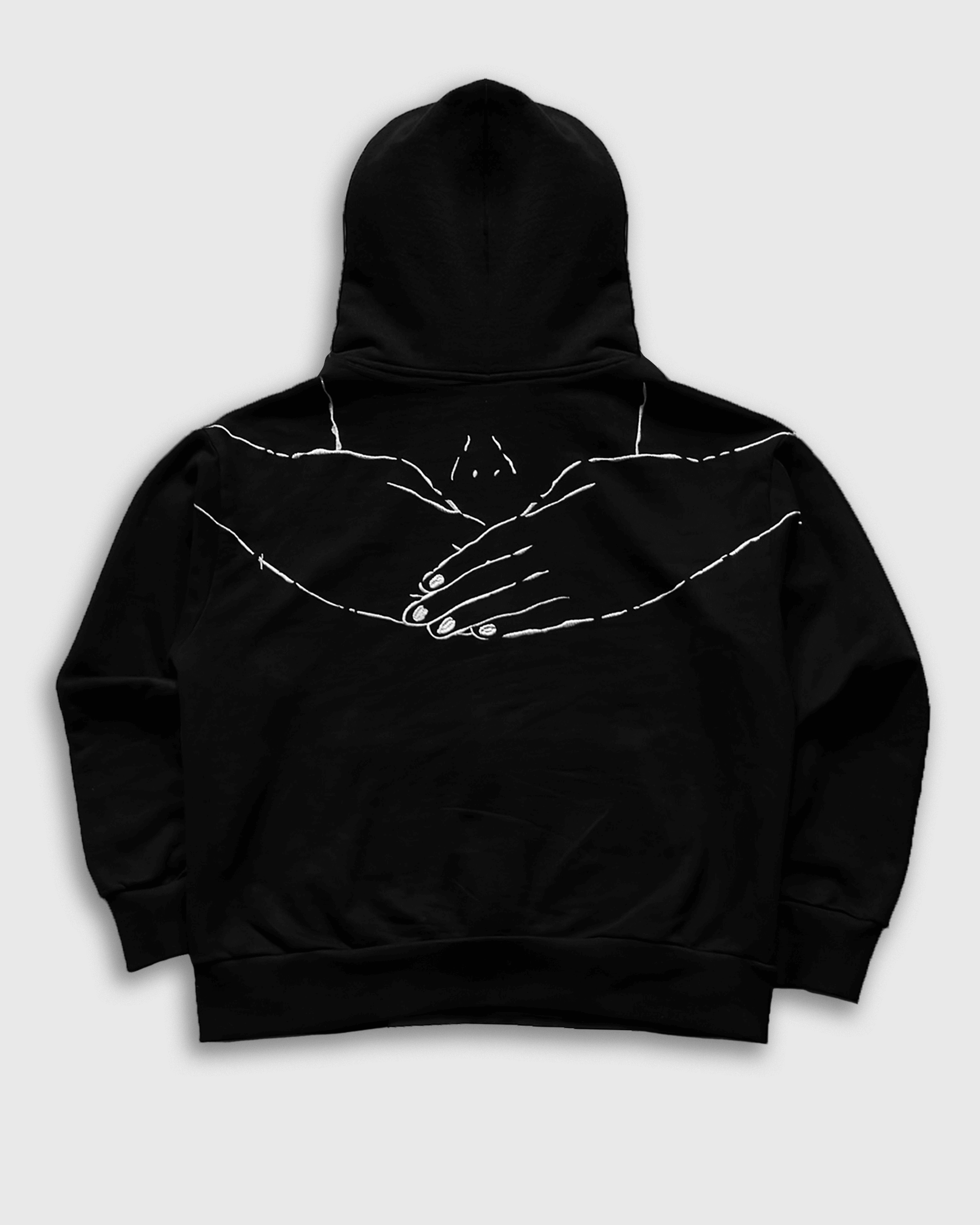 Black hoodie with white hand design on a light gray background