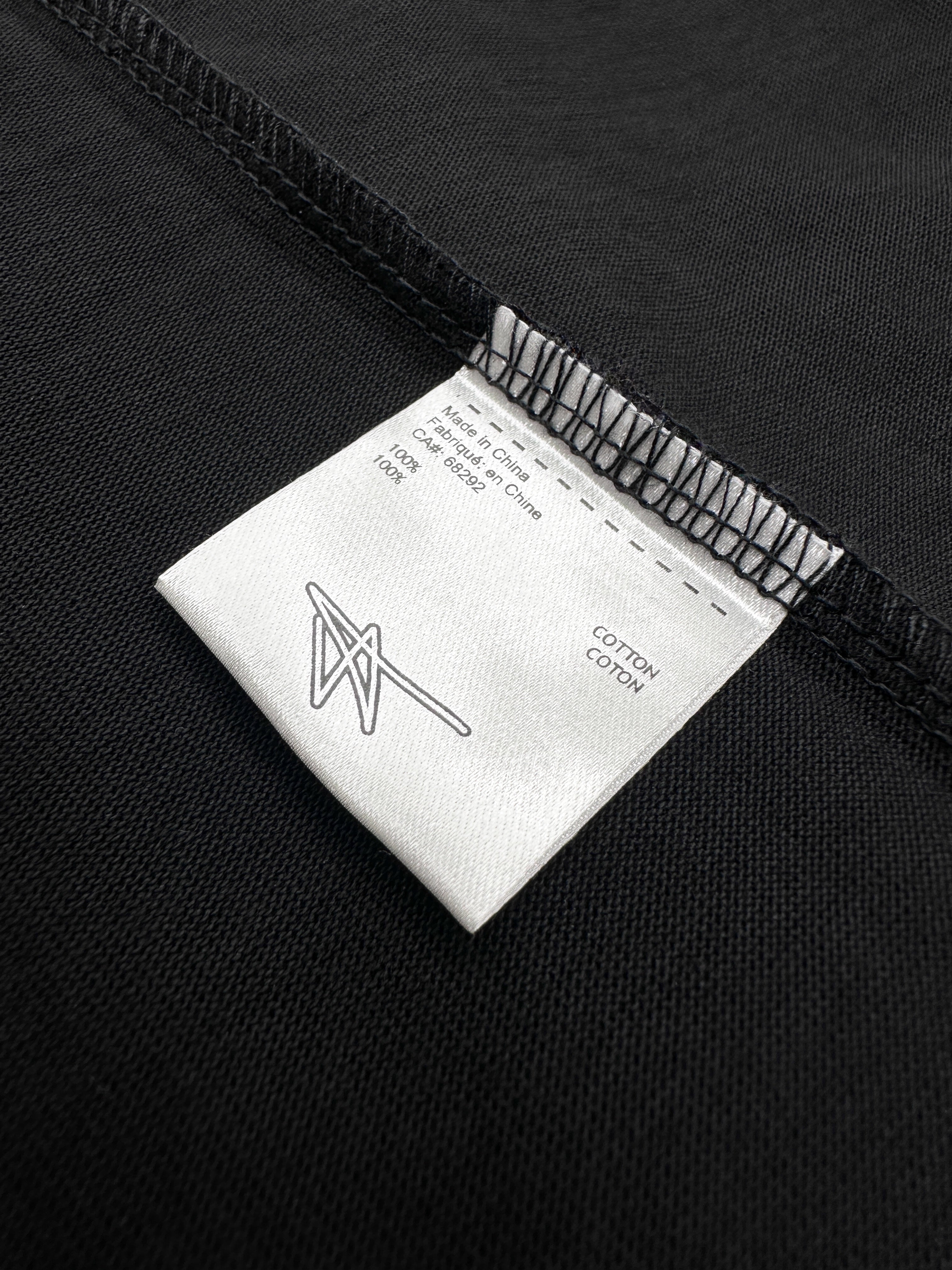 Close-up of a label on black fabric with text and a logo.