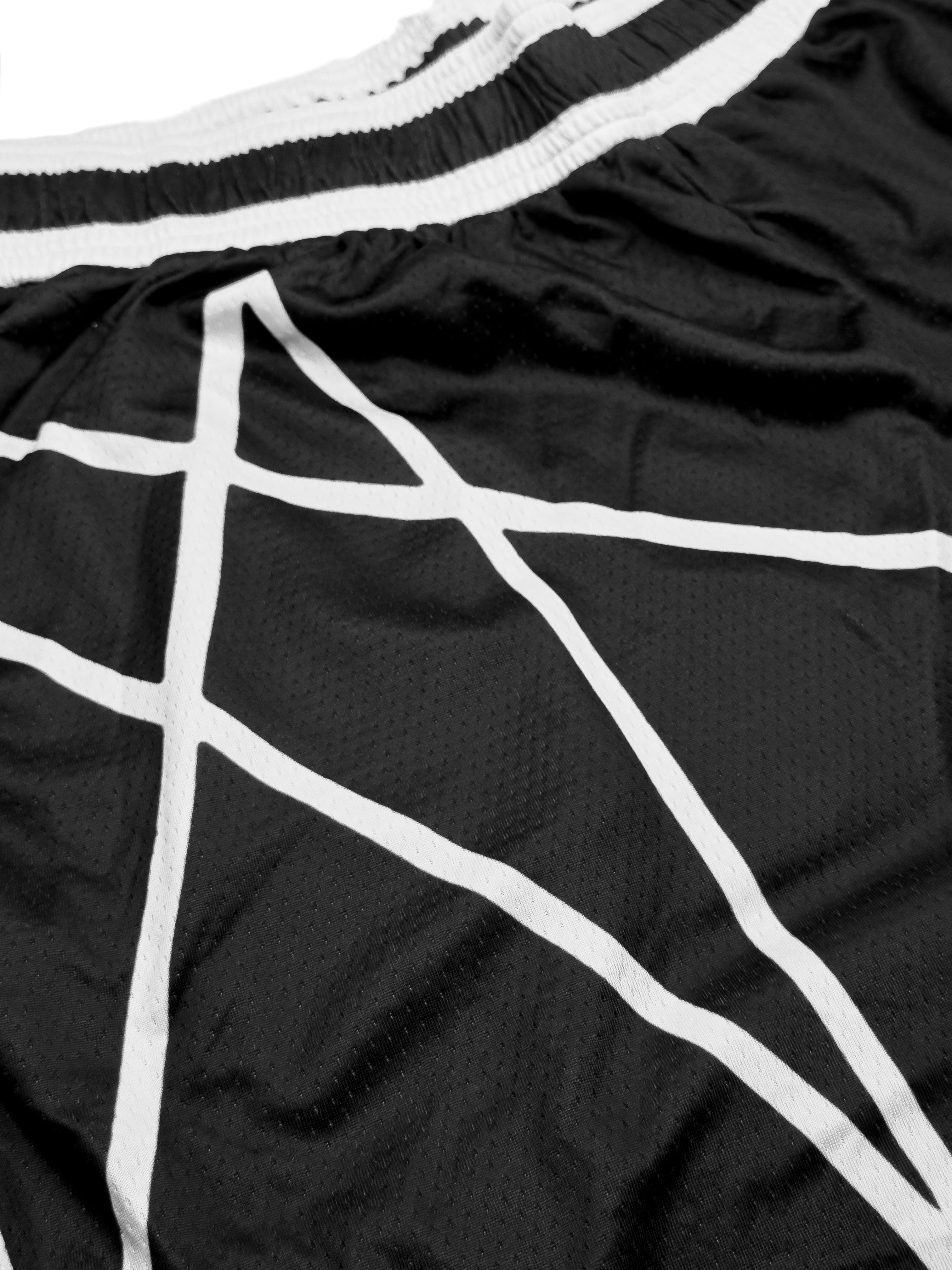 Black athletic shorts with white grid pattern and waistband