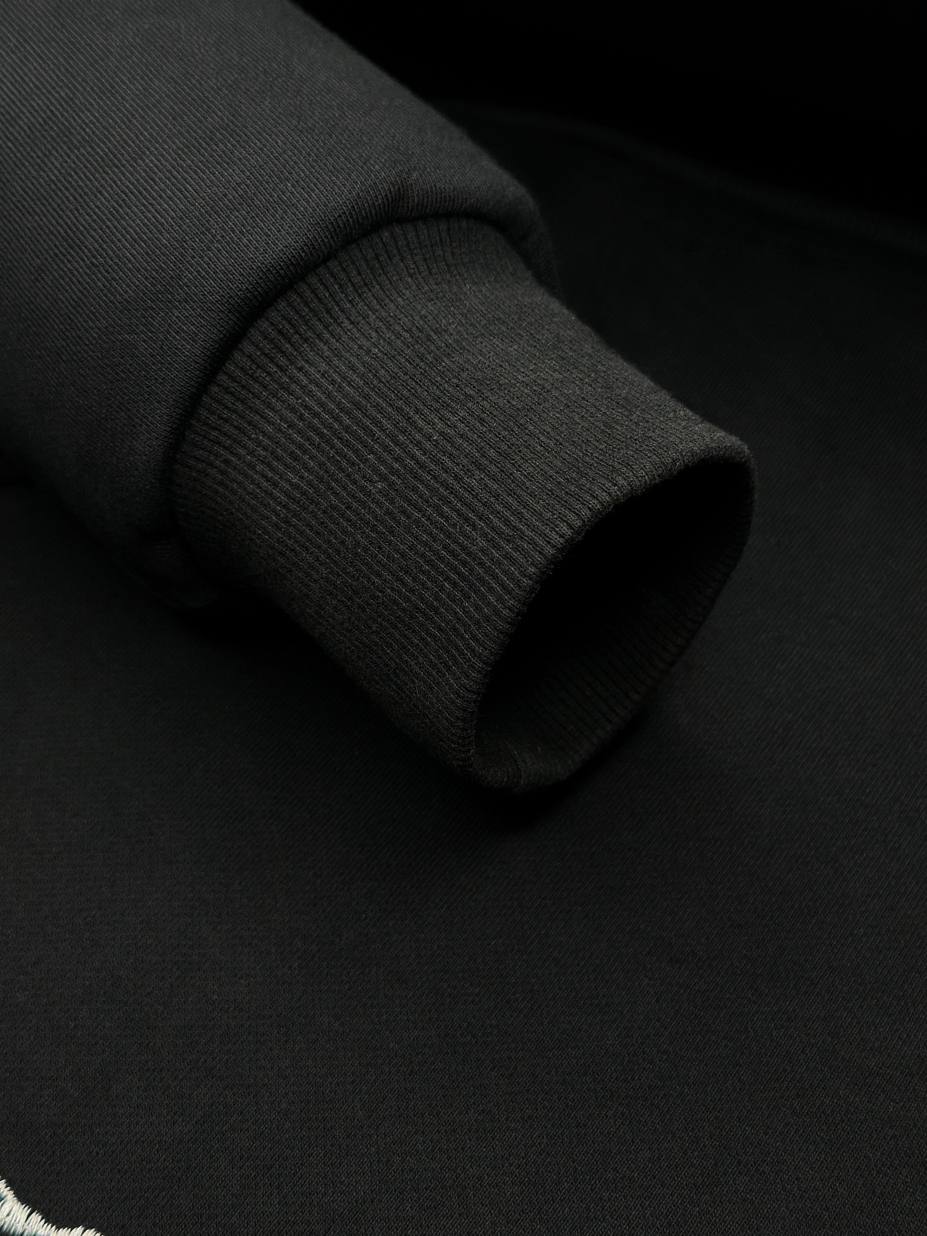 Close-up of a black sweatshirt with white text on a black background