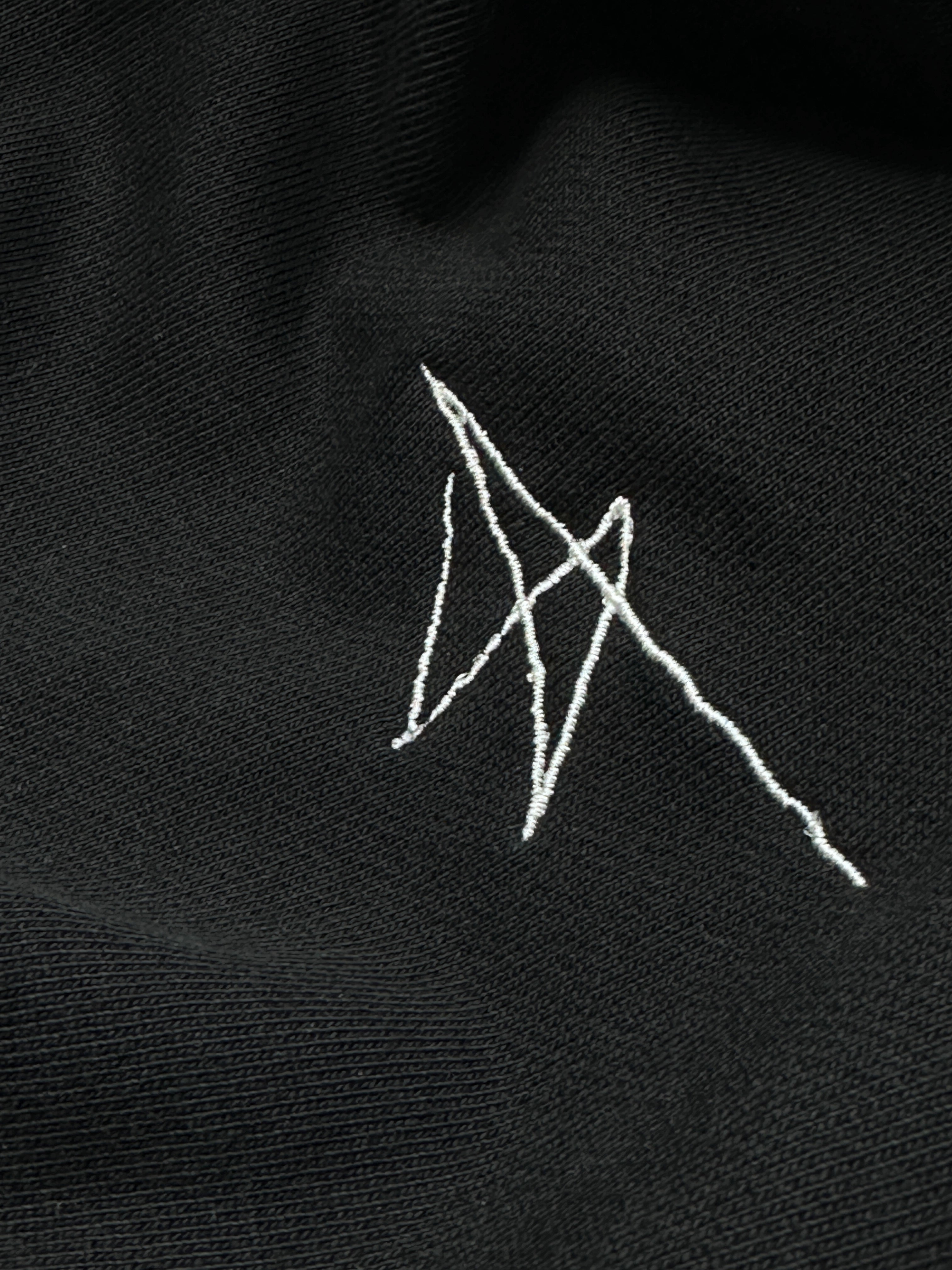 White embroidered design on a black fabric background